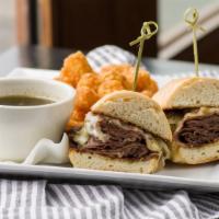 French Dip · Slow roasted beef dipped in our herbed au jus with Swiss cheese & caramelized onions on a Fr...