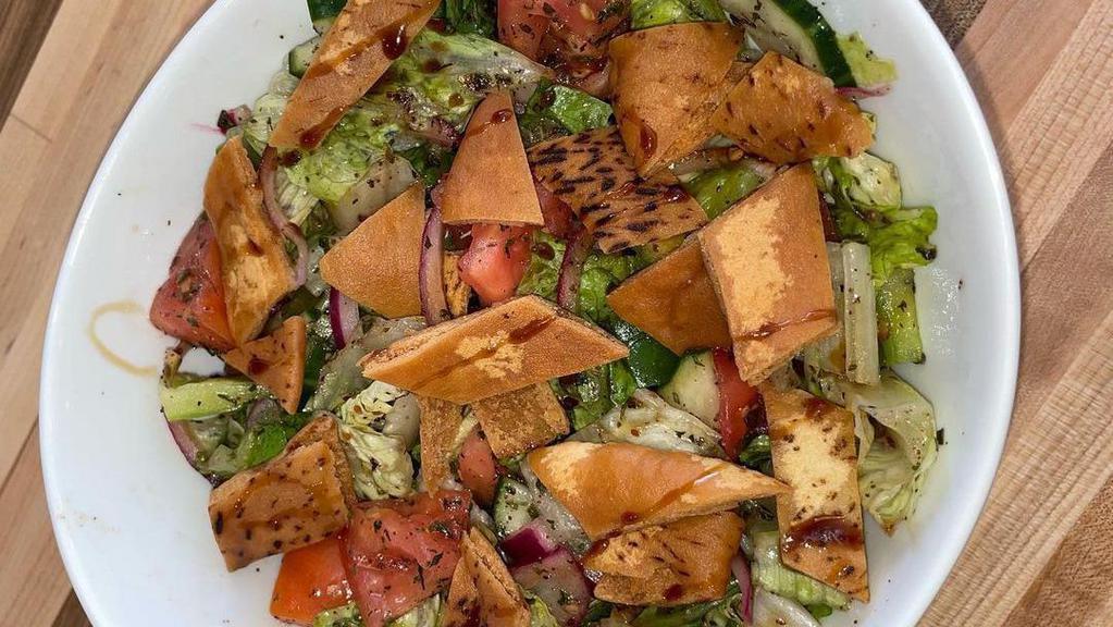 Fattoush Salad · Served with fresh lettuce, tomatoes, cucumbers, onions, and fried pieces of pita bread with our special fattoush dressing.