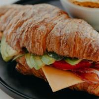 Croissant Sandwich · Toasted croissant, housemade garlic aioli, bacon, cheddar cheese, spinach, tomato, and avoca...