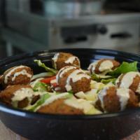 Falafel Plate · Eight falafel balls drizzled with tahini sauce on a bed of salad with lemon juice and olive ...