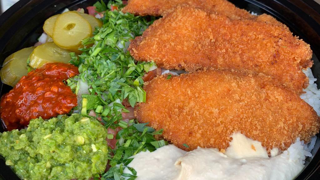 Schnitzel Plate · Our homemade breaded chicken on a bed of rice with salad, hummus, and a freshly baked pita bread.