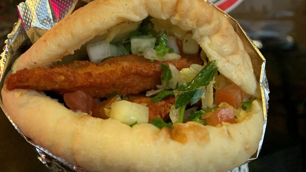 Schnitzel Pita · Breaded chicken deep fried in a pita with hummus, salad, hot sauce, and tahini sauce.