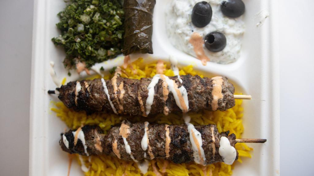 Kafta Over Rice · Long-grain basmati or yellow rice served with grilled ground lamb and beef rissole and Greek salad.