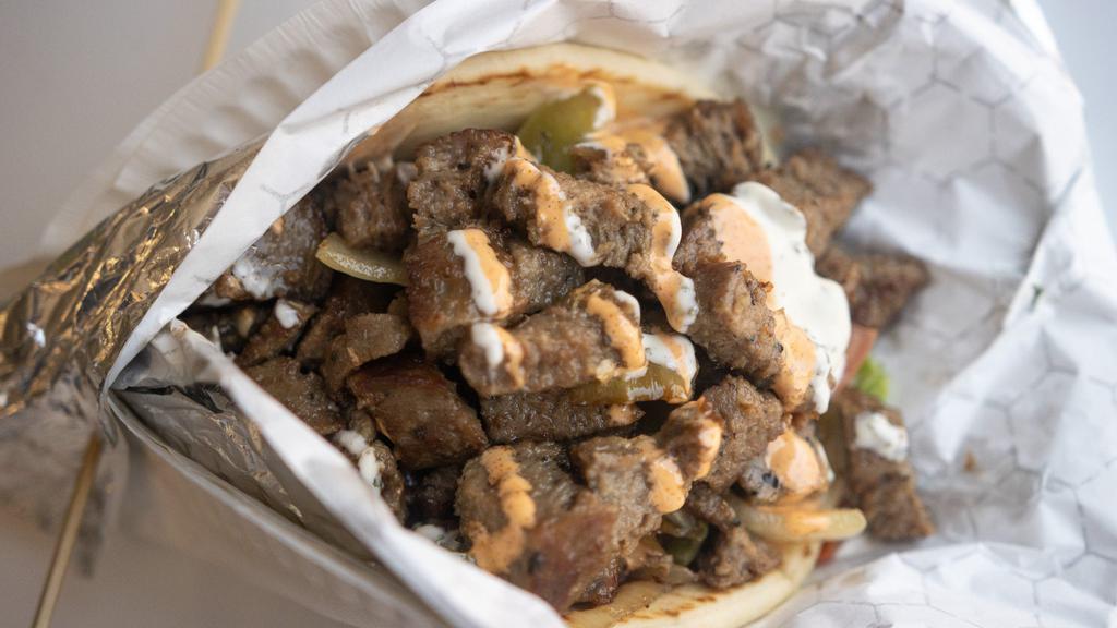 Lamb Gyro · Slow roasted lamb slices, seasoned with our special Mediterranean spices topped with tzatziki sauce and wrapped in a soft, warm pita.