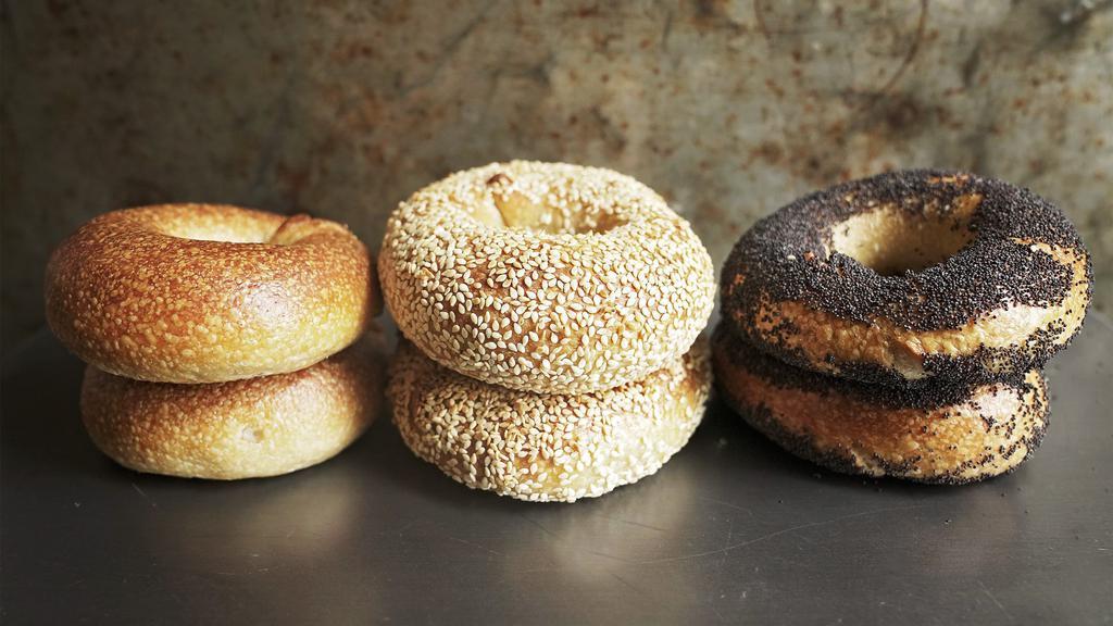 Half Dozen Assorted Bagels · Our organic naturally-leavened bagels are hand-rolled, given a long ferment, and have just a hint of rye, which adds to their depth of flavor. The caramelized crust has a glossy sheen and the airy interior has a tight, springy crumb that balances the mild tang of sourdough with just enough malty sweetness. 6 count. The assortment will include a variety of flavors based on what we currently have available (plain, salted, sesame, poppy seed and everything). 6 count