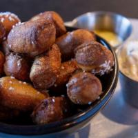 Pretzel Bites · Vegetarian. Soft pretzel bites with sides of stone ground mustard & a spicy three cheese spr...