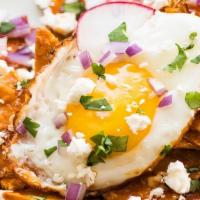 Chilaquiles Rojos · House-made tortilla chips tossed in a red chile sauce topped with diced onion, sour cream, q...