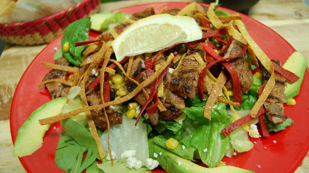 Southwest Fajita Salad · Romaine, spinach, iceberg lettuce, corn, black beans, queso fresco, avocado slices and choice of chicken or Angus steak. Served with tortilla strips.