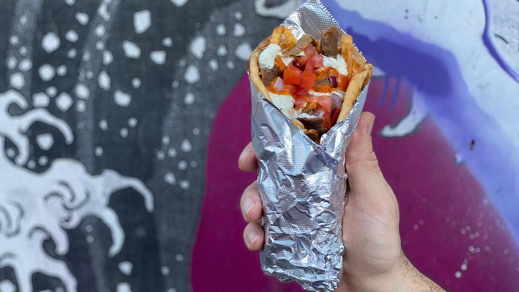 Street Greek Gyro · Choice of protein with zesty feta, berliner sauce, tzatziki, onion, tomato and french fries...all wrapped in a pillowy pita.