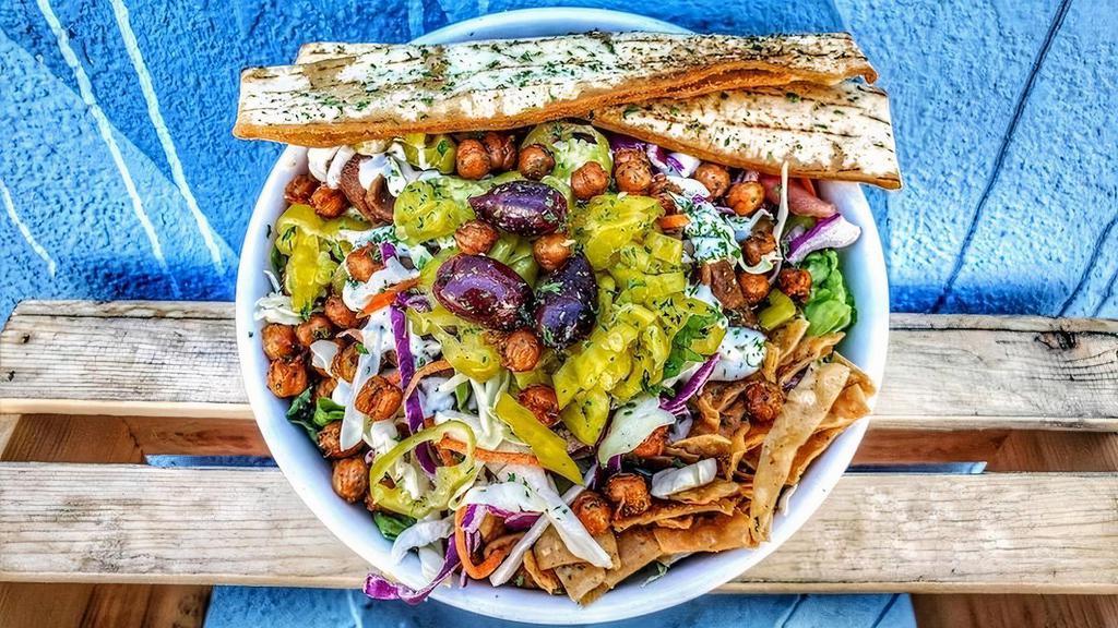 The Doner Salad · Romain, cabbage, carrot, onion, green pepper, cucumber, olives, feta, pepperoncinis, tomato, tzatziki, fried lavash chips, crispy garbanzo, fried pita, and a side of balsamic dressing.