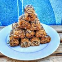 Bite Sized Baklava Nut Roll · Rolled flaky filo dough, almonds, walnuts and honey. Drizzled with chocolate