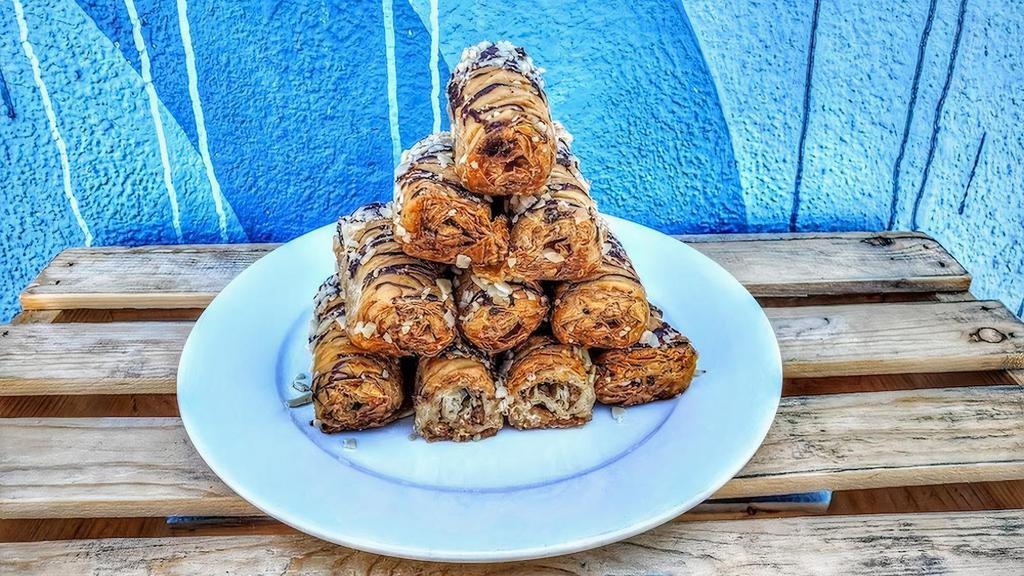 Bite Sized Baklava Nut Roll · Rolled flaky filo dough, almonds, walnuts and honey. Drizzled with chocolate