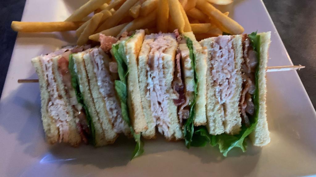 Turkey Club Sandwich · A triple decker filled with roasted turkey, bacon, crisp lettuce, and tomatoes. Served on toasted white bread and accompanied with fries.