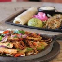 Vegan Flaming Chick’N Fajitas · Marinated fajita chicken strips served over sizzling peppers and onions. Vegan sour cream, g...