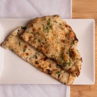 Garlic Naan · Naan Bread Topped With Pressed Garlic & Fresh Herbs