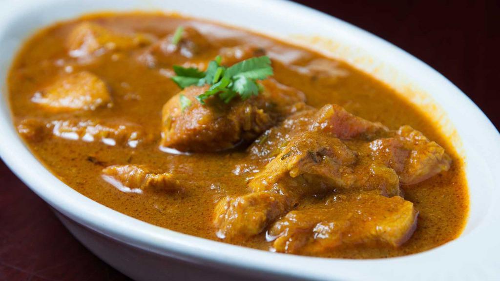 Chicken Curry · Boneless chicken tender cooked in a rich curry of onions, tomatoes, ginger, garlic and spices. All entrée are served with basmati rice and garnished with cilantro.