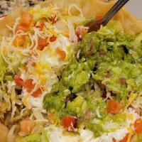 Taco Salad · Layered with meat, beans, lettuce, tomatoes, cheese, guacamole and sour cream.