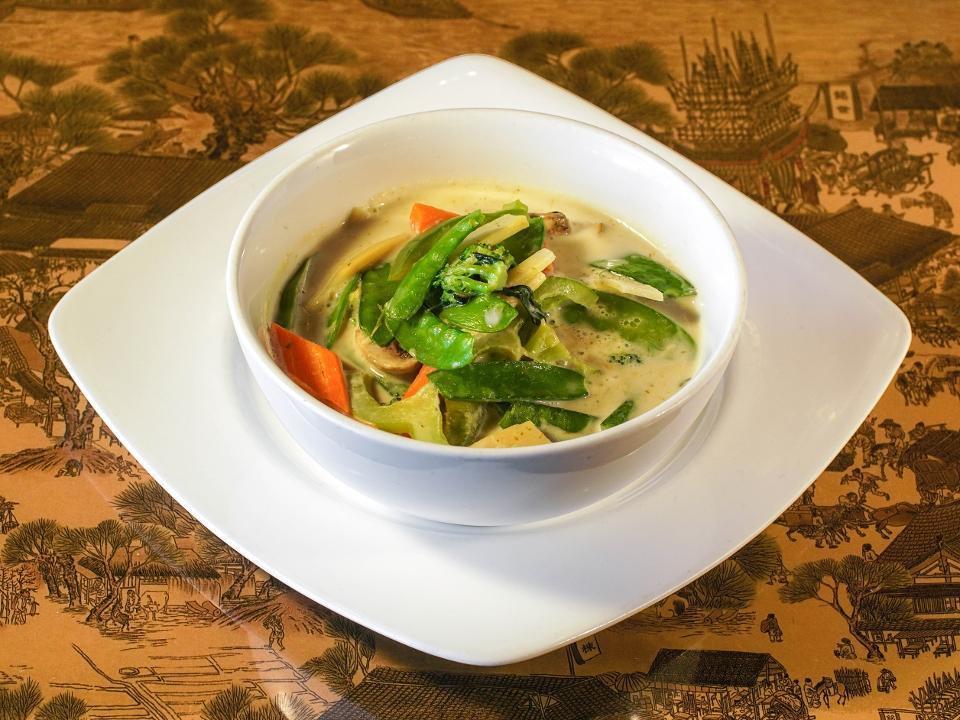 Green Curry · Bamboo, bell peppers, and basil simmered with coconut milk in fresh green chili, wild ginger, lemongrass, and kaffir lime curry paste.
