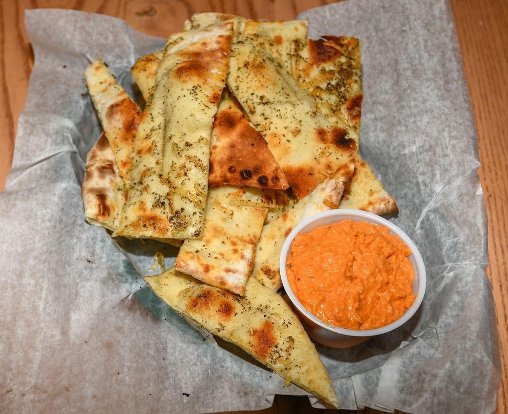 Hummus Flatbread · Our roasted red pepper hummus served with fresh-made, oven flatbread that is sprinkled with olive oil and parmesan cheese.