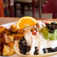 Huevos Rancheros · Two poached eggs over grilled corn tortillas with black beans, jack cheese, housemade salsa,...