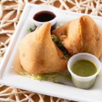 Veg Samosa (2 Pieces) · Savory deep fried pastry puffs filled with mild spiced potato and peas.