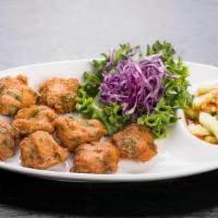 Tod Mun Pla · Deep-fried homemade fish cakes served with a side of cucumber-plum sauce topped with crushed...
