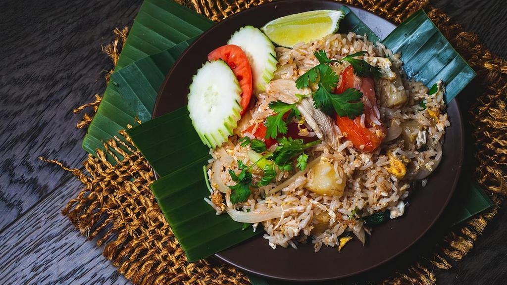 Pineapple Fried Rice · A popular Thai variation on fried rice, this dish adds pineapple pieces and includes stir-fried jasmine rice, egg, and a mix of white onions, tomatoes, and assorted vegetables.