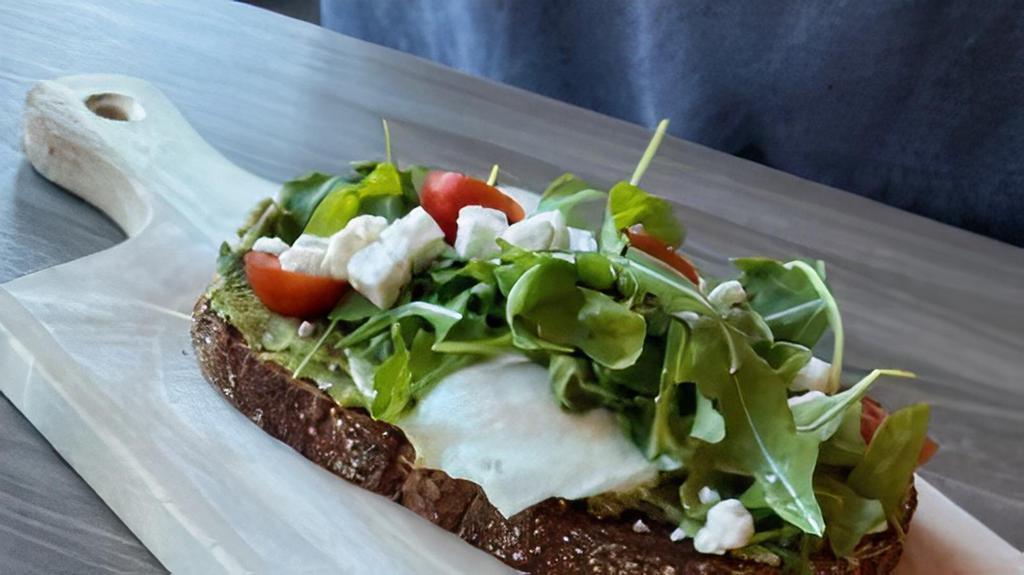 Avocado Toast · Whole grain bread, smashed avocado whole grain bread, smashed avocado, and over-easy egg topped with baby arugula and cherry tomatoes.