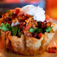 Taco Salads · Served in a crunchy taco shell with shredded romaine lettuce, black or ranchero beans, Spani...