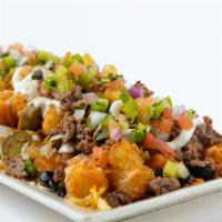 Nachos Or Totchos · Fresh tortilla chips with queso, shredded cheddar jack cheese, olives, green chiles, jalapeñ...