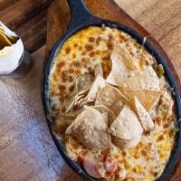 Queso Fundido · Six melted cheeses, salsa negra, crema oaxaquena, tortilla chips