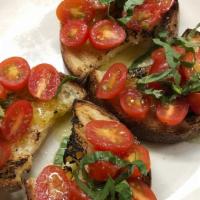 Bruschetta Al Pomodoro · Vegan. Dairy-Free. Toasted bread topped with tomatoes, basil, garlic, & olive oil.