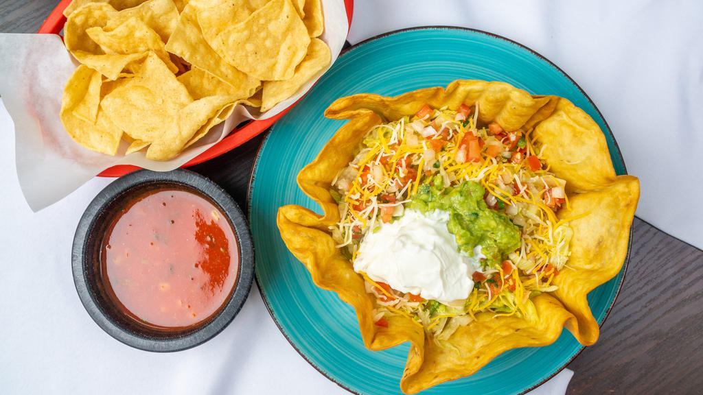 Taco Salad · Crispy flour tortilla shell filled with shredded beef, ground beef, or shredded chicken, topped with lettuce, cheese, sour cream, guacamole and Pico de Gallo.