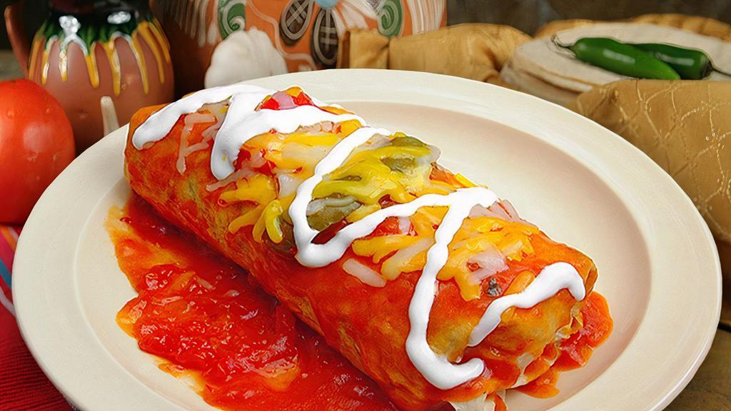 Wet Combo Burrito · Our burrito (your choice of meat, beans, rice, onion, and cilantro) drenched in salsa ranchera, cheese and sour cream.