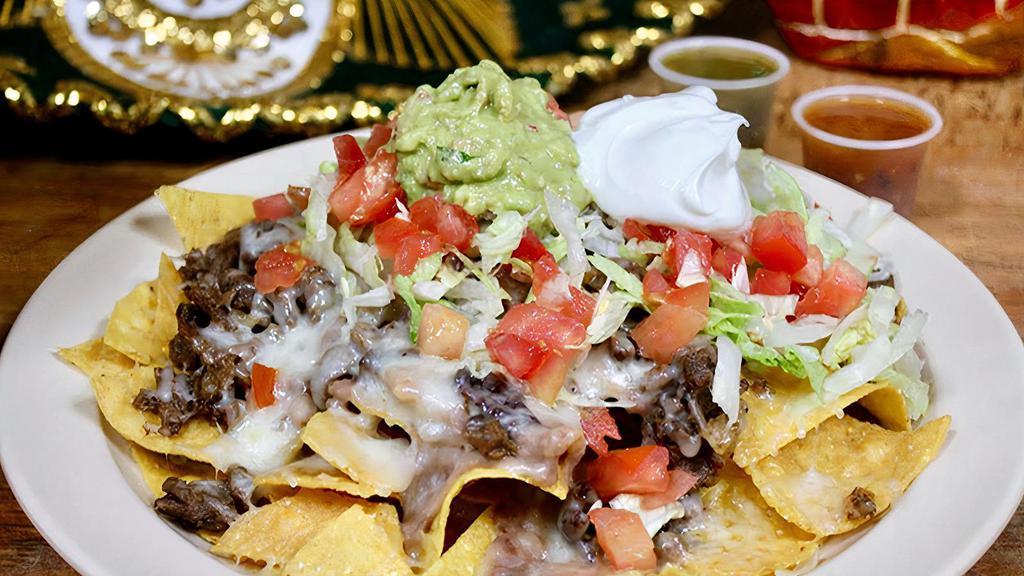 Nachos · Nachos include choice of meat, beans, cheese, lettuce, tomato, guacamole, and sour cream.