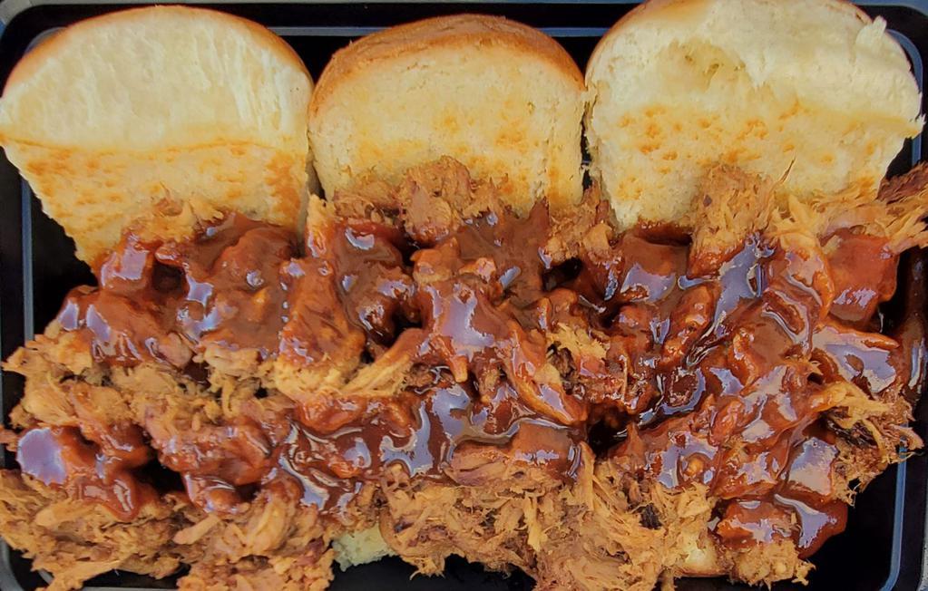 Pulled Pork Sliders · We start by slowly smoking our pork butt for 18 hours and then painstakingly  pulling it apart then we place it on 3 toasted Brioche buns and then we drizzle Traeger sweet and heat BBQ sauce over the meat and then we smother it in our custom Cole slaw to bring it all together. Served with a side of our Cole slaw and BBQ Beans