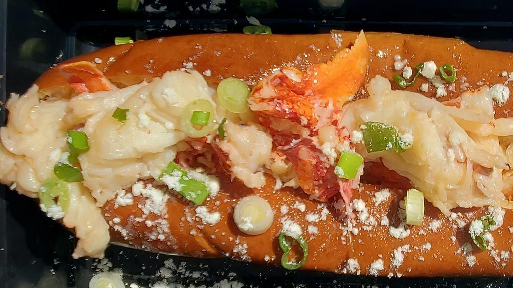 Lobster Roll · 1/4 lb. Fresh Maine Lobster flown in fresh daily, sautéed  in clarified gee butter placed on a toasted 8-in Brioche roll and topped with chopped green onions and sprinkled with butter dust with a little more butter drizzled over the top