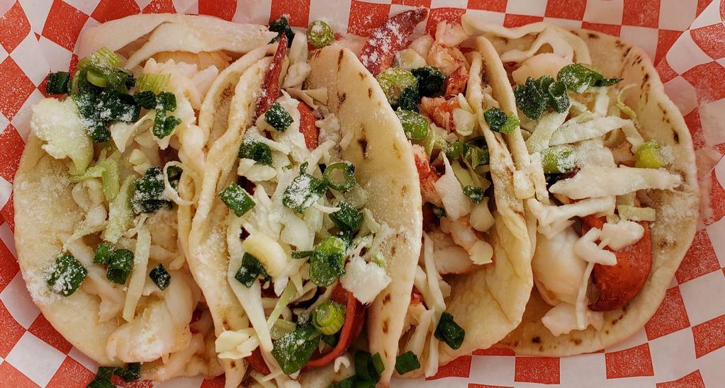 Crab Baja Taco · Four tacos on toasted flour tortillas with 1/4lb of fresh Alaskan king crab  sauteed in clarified butter topped with sliced green onions, cabbage, and butter dust