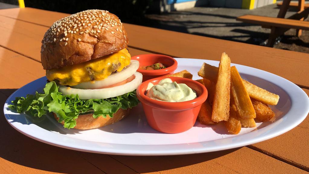 Cheeseburger And Yuca Fries. · Beef patty, american cheese, lettuce, tomato, onion, house made pickles, burger sauce. Served with yuca fries and lime cilantro aioli.