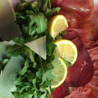 Insalata Bresaola · Dry cured beef with arugula and lemon, extra virgin olive oil and parmigiano.