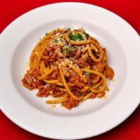 Bucatini All'Amatriciana · Bucatini pasta with pancetta, onion, pecorino, in a red wine and tomato reduction sauce.