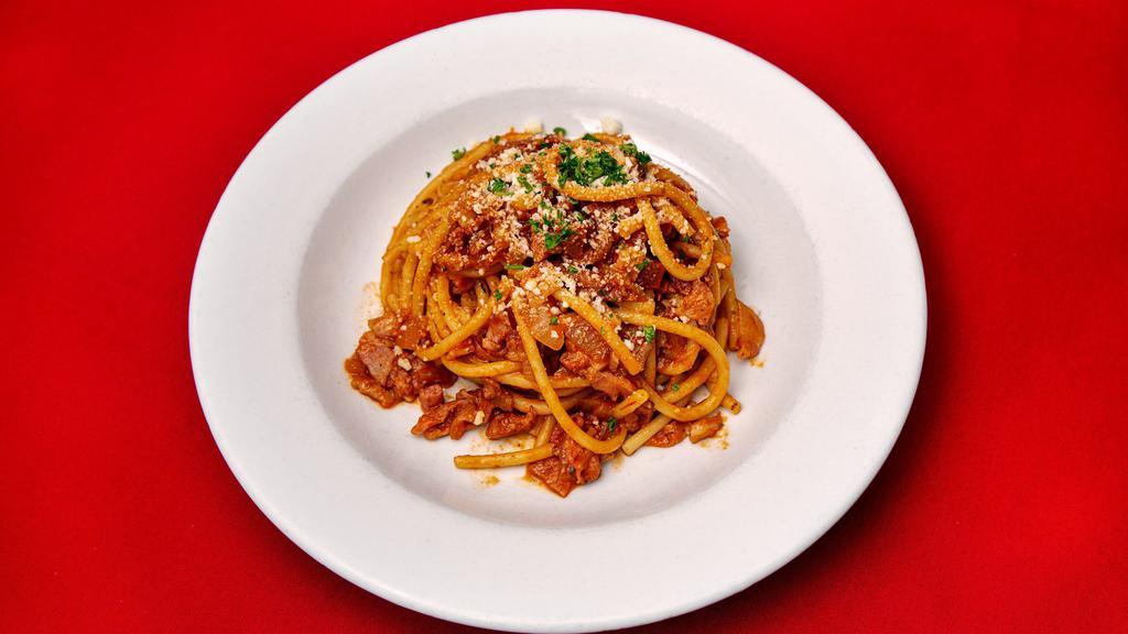 Bucatini All'Amatriciana · Bucatini pasta with pancetta, onion, pecorino, in a red wine and tomato reduction sauce.