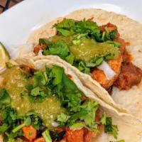 Tacos Al Pastor  · Pork marinated in a chili and pineapple sauce, onion and hot sauce. Two per order.