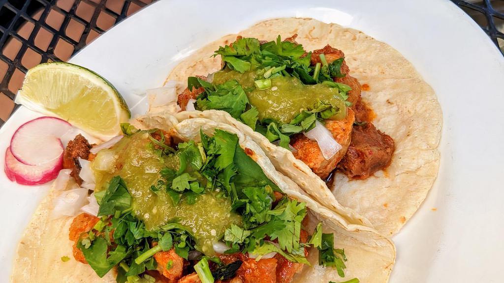 Tacos Al Pastor  · Pork marinated in a chili and pineapple sauce, onion and hot sauce. Two per order.