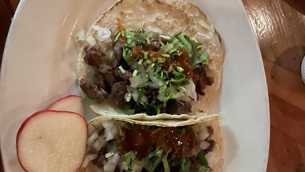Tacos De Asada · Beef on two fresh homemade tortillas, topped with , onion and hot sauce. Two per order.