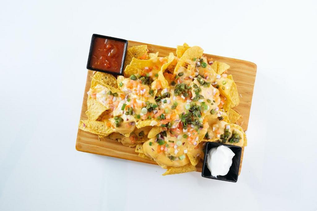 Nachos · tortilla chips, cheese, green onions, fire-roasted jalapenos, diced tomatoes, diced onions, salsa, sour cream, guacamole