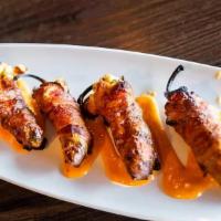 Bacon Wrapped Jalapeños · Fresh jalapeño stuffed with a cream cheese shrimp filling, jack cheddar cheese and wrapped i...