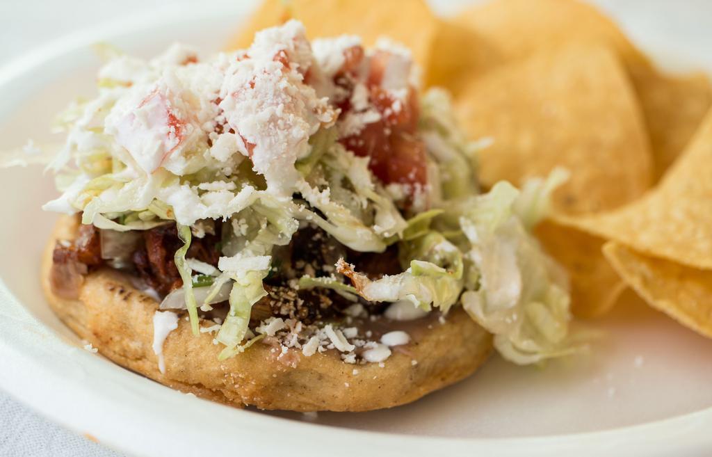 Sopes · Choice of meat, beans, lettuce, tomato, onions, cilantro, salsa, Mexican crema & Cotija cheese on top of a thick, fried tortilla.
