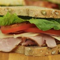 Ham & Swiss · Tender slices of honey ham, Swiss cheese, lettuce, tomato and red onion - served on Honey Wh...