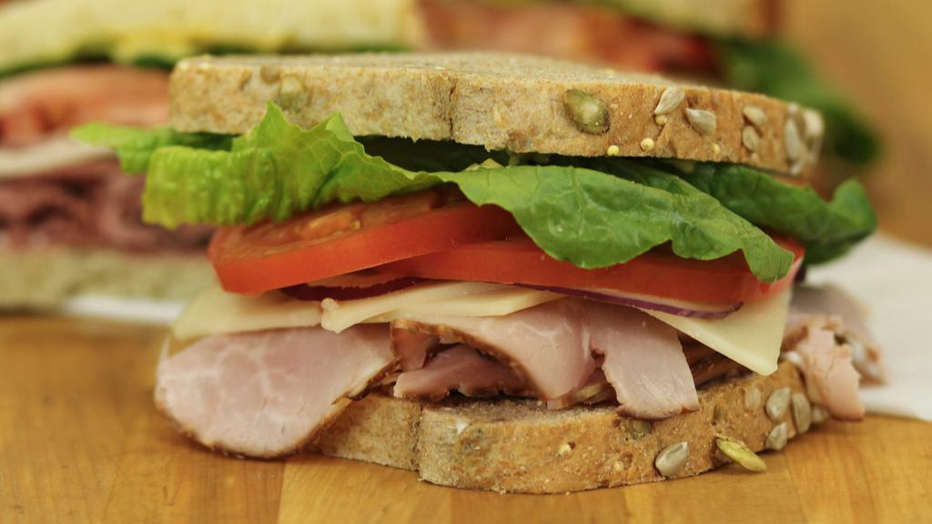 Ham & Swiss · Tender slices of honey ham, Swiss cheese, lettuce, tomato and red onion - served on Honey Whole Wheat bread.